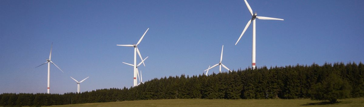 Ein Windpark mit mehreren Windrädern und einem blauen Himmel